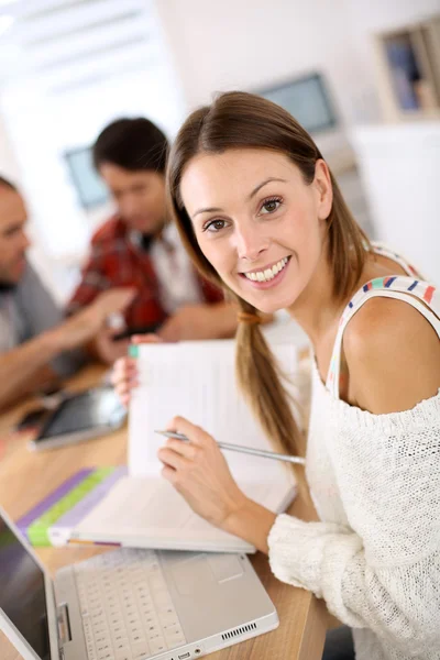 Chica estudiando con portátil y libro —  Fotos de Stock