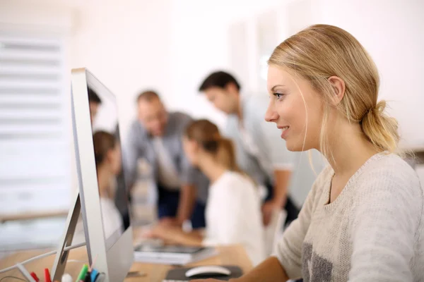 Menina no escritório trabalhando no computador desktop — Fotografia de Stock