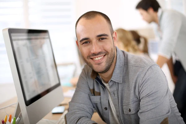 Guy sitting in front of desktop computer — Stock Photo, Image