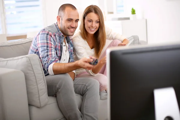 Casal em casa à procura de progam tv — Fotografia de Stock