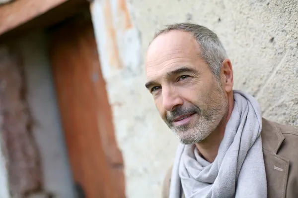 Senior man leaning against wall — Stock Photo, Image