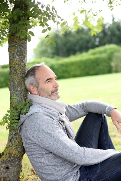 Mann sitzt im Park — Stockfoto