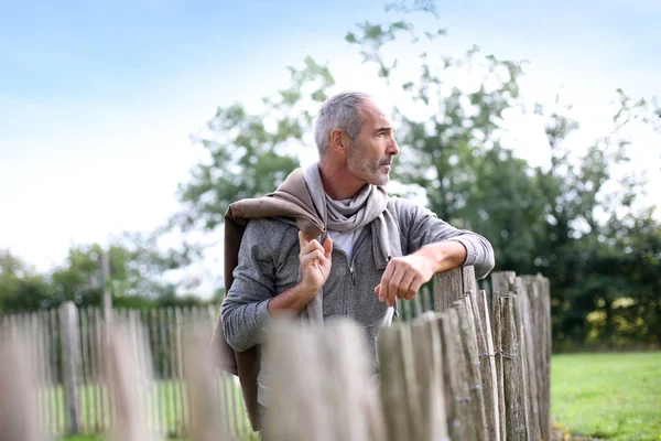 Uomo maturo in piedi vicino alla recinzione — Foto Stock