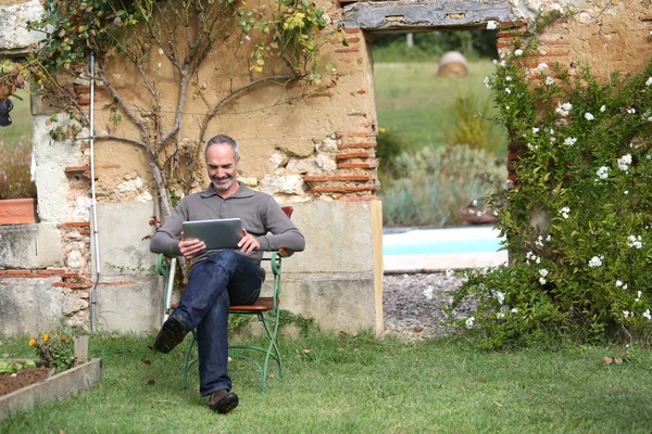 Uomo relax con tablet in giardino privato — Foto Stock