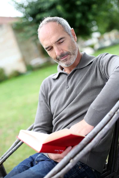 Senior man lezing roman — Stockfoto