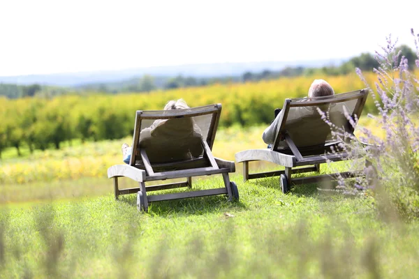 Mensen ontspannen in lange stoelen — Stockfoto