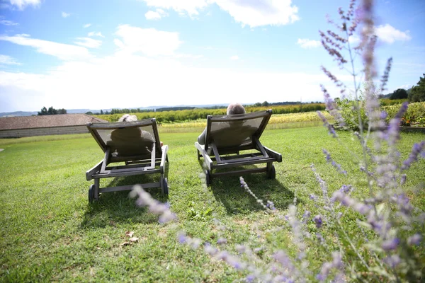 Mensen ontspannen in lange stoelen — Stockfoto