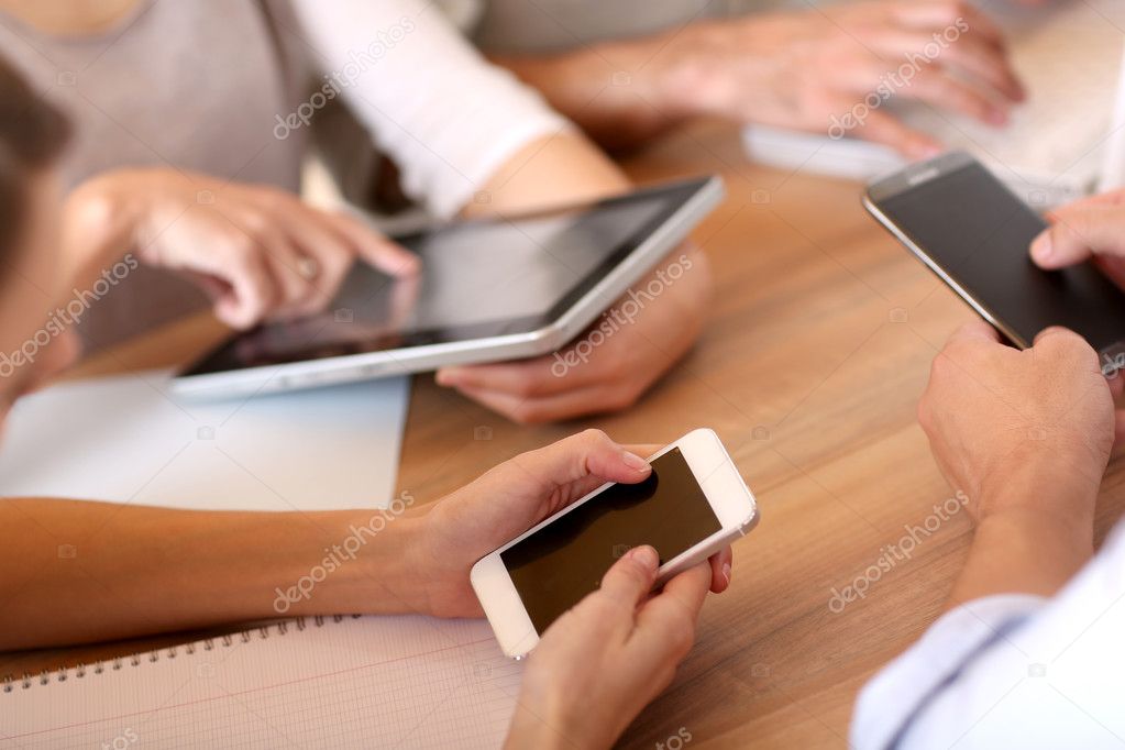 Group of business people using electronic devices at work