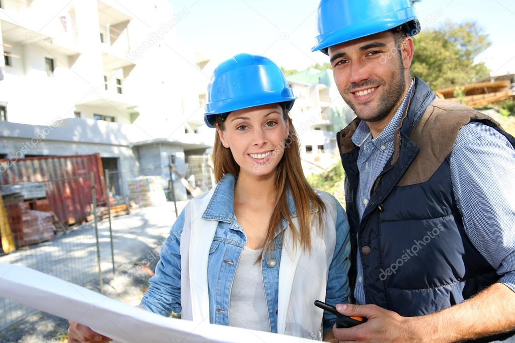 Smiling architects standing on construction site