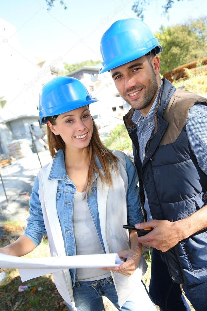 Smiling architects standing on construction site