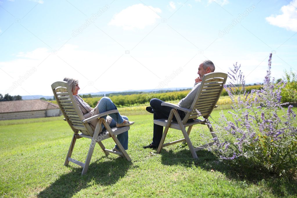 People relaxing in long chairs