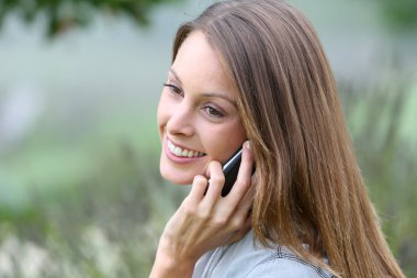 Kadın cep telefonuyla konuşuyor.