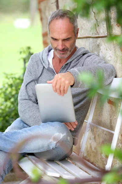 Mogen man med tabletten på en bänk — Stockfoto