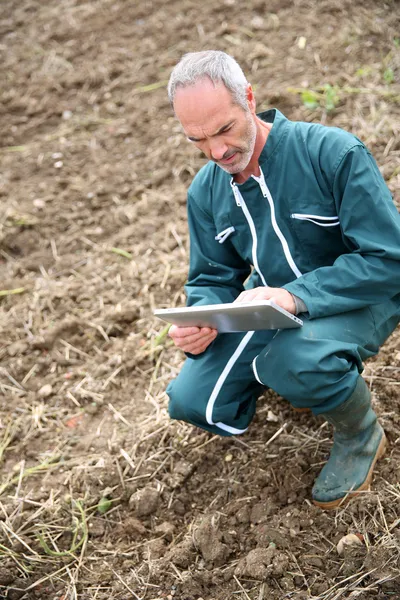 Farmář v poli pomocí digitálních tablet — Stock fotografie