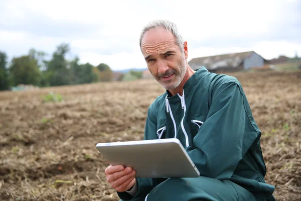 Agricultor en el campo usando tableta digital — Foto de Stock