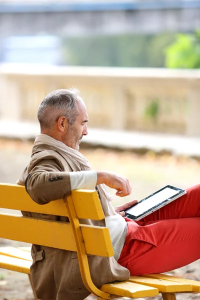 Senior homem relaxante no banco — Fotografia de Stock