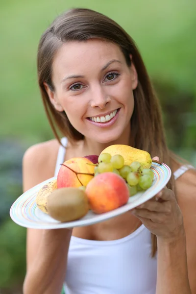 Ragazza che tiene frutta fresca — Foto Stock