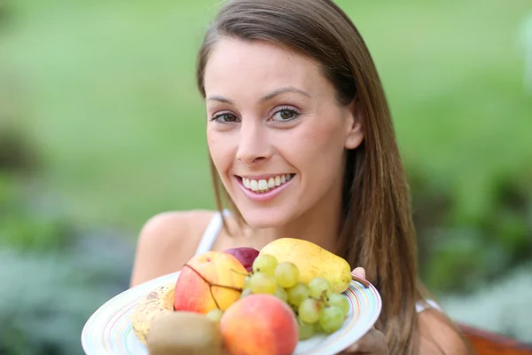 Meisje bedrijf vers fruit — Stockfoto