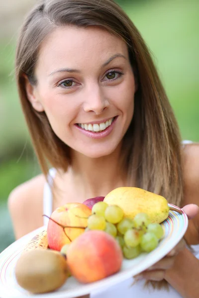 Meisje bedrijf vers fruit — Stockfoto