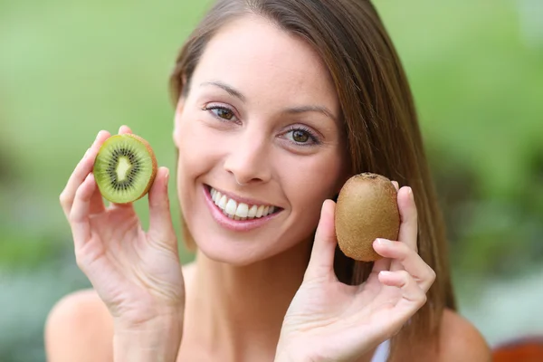 Girl eating kiwis — Stock Photo, Image