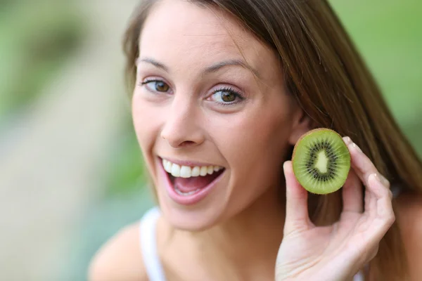 Girl eating kiwis — Stock Photo, Image