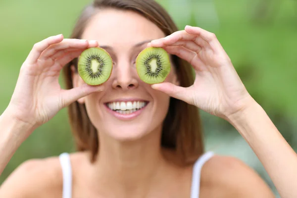 Chica mostrando rodajas de kiwi —  Fotos de Stock