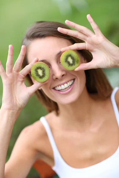 Menina mostrando fatias de kiwi — Fotografia de Stock