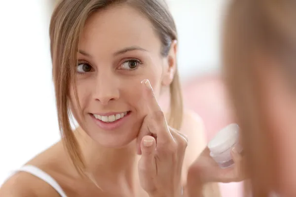 Mädchen trägt Anti-Aging-Creme auf ihr Gesicht — Stockfoto