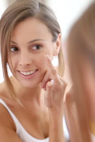 Meisje anti-aging crème op haar gezicht te zetten — Stockfoto