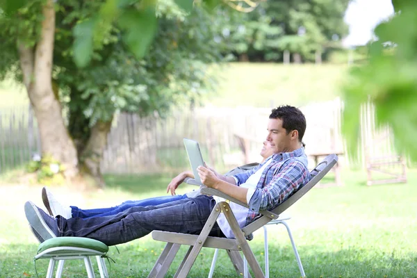 Couple relaxing in long chairs — Stock Photo, Image