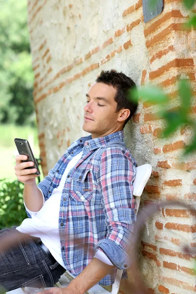 Człowiek na ławce z smartphone — Zdjęcie stockowe