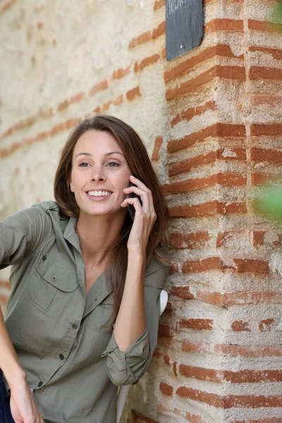Девушка в саду разговаривает по телефону — стоковое фото