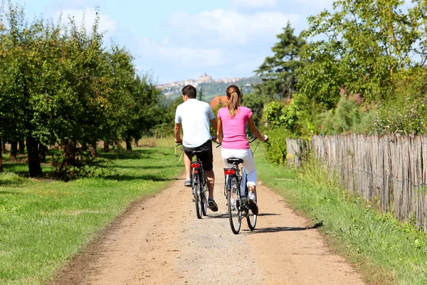 Man and woman riding bicycles — Stock Photo, Image