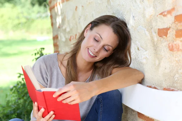 Jenta leser bok utenfor – stockfoto