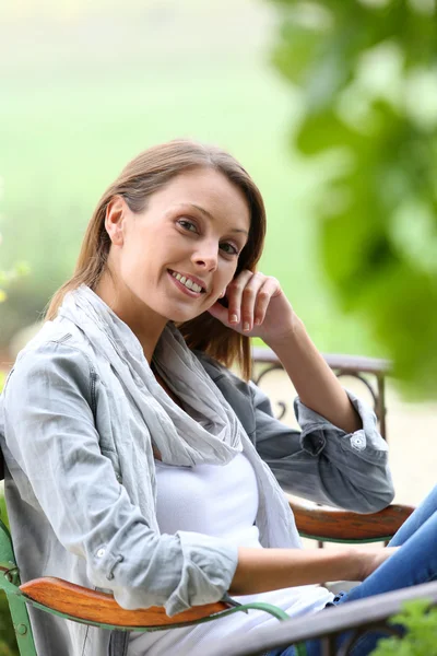 Mujer relajante en silla en jardín — Foto de Stock