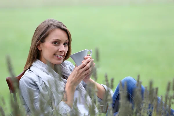 Vrouw drinken koffie in de tuin — Stockfoto