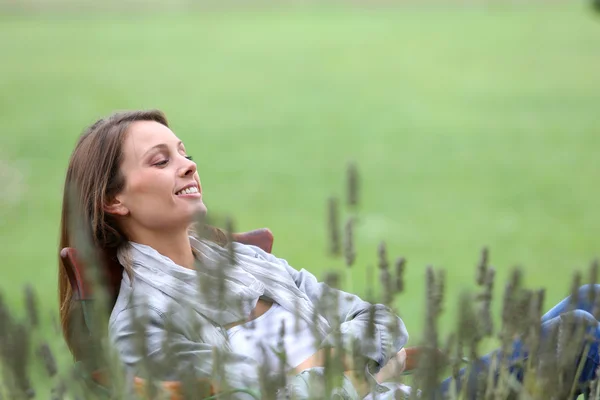 Frau entspannt sich im Stuhl im Garten — Stockfoto