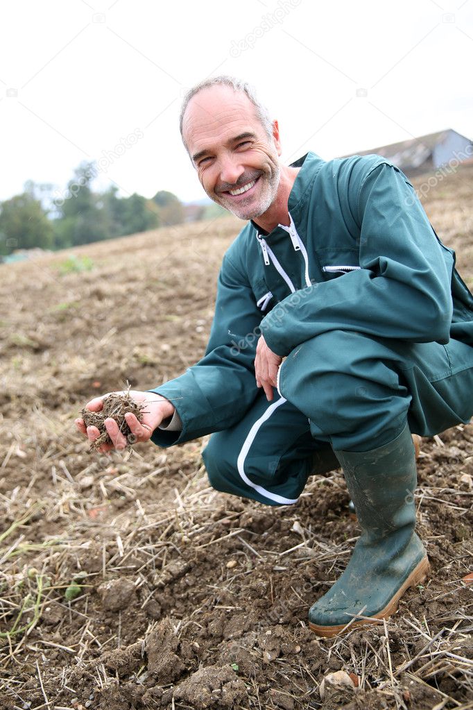 Farmer looking at ground quality