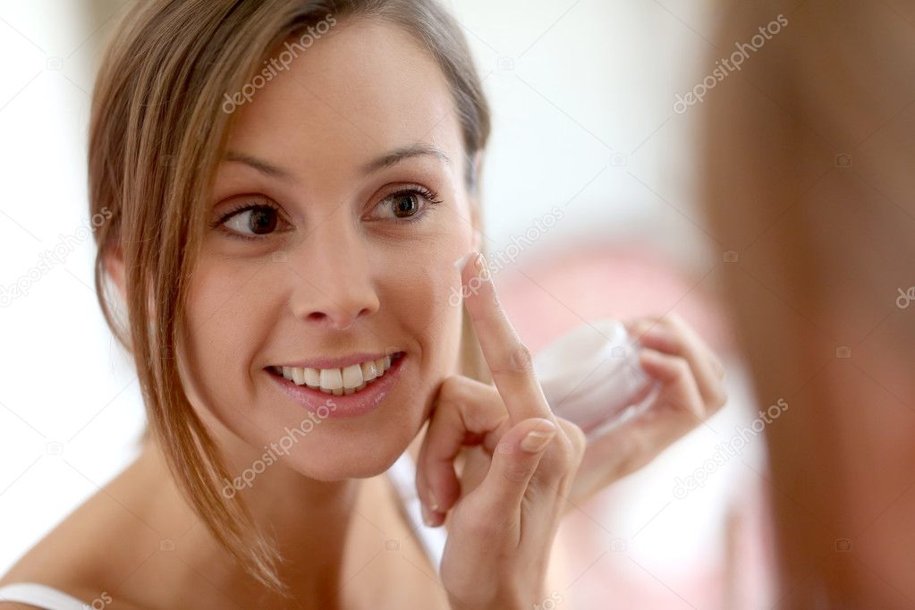 Girl putting anti-aging cream on her face