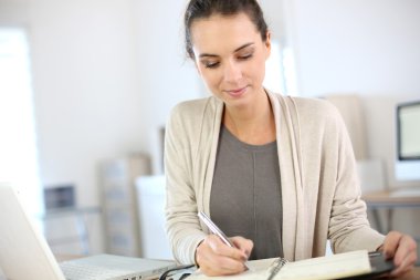 Businesswoman writing on agenda clipart