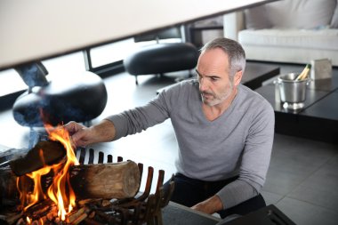 Mature man preparing fire clipart