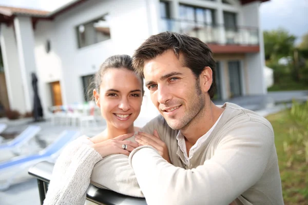 Cheerful couple in front of new home — Stock Photo, Image