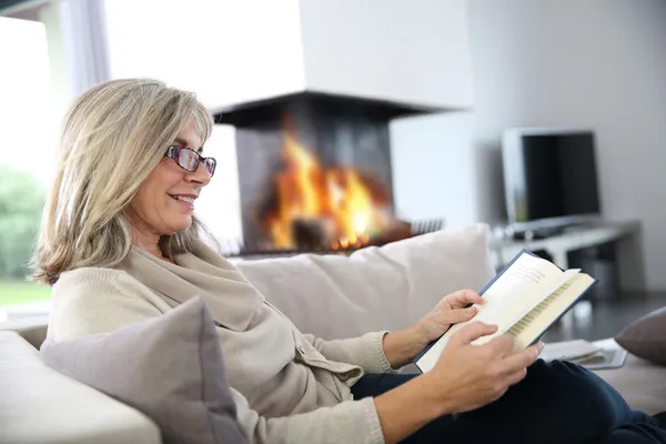 Woman reading book at home