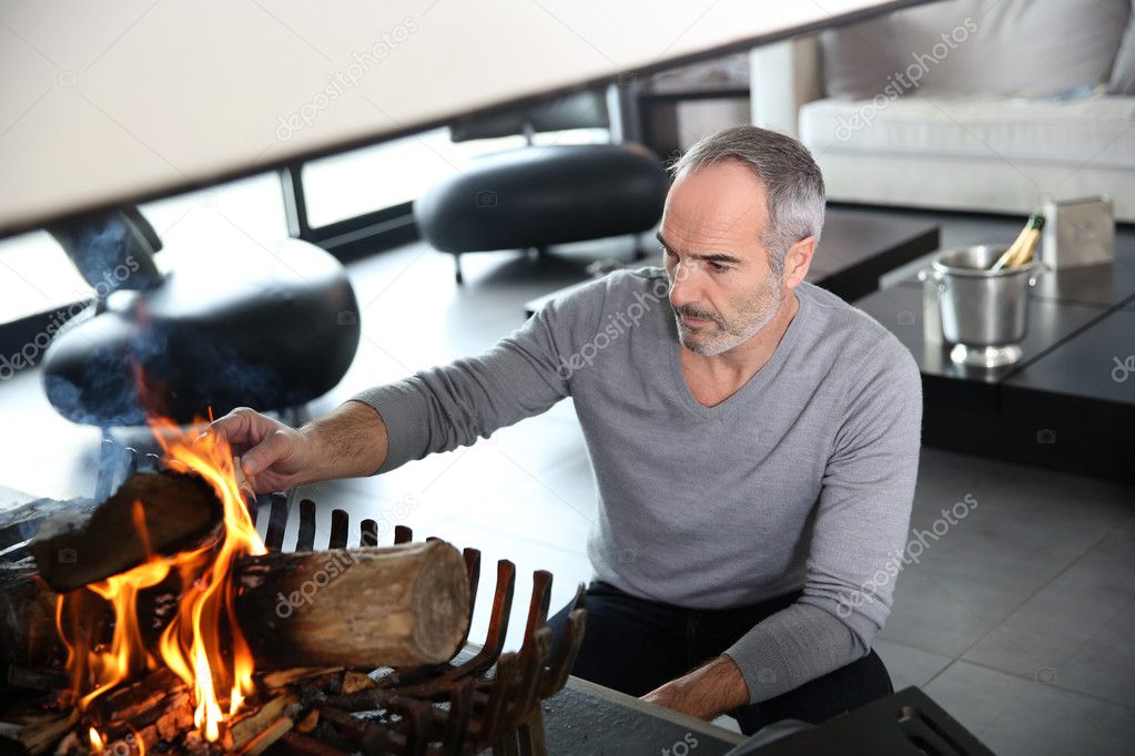 Mature man preparing fire