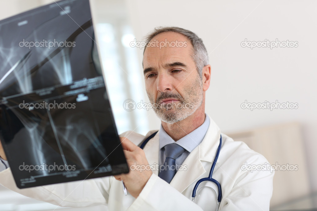 Mature doctor looking at X-ray results