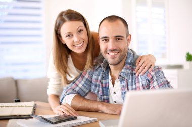 Smiling couple calculating savings