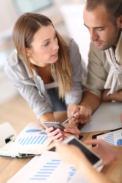 Businesspeople using smartphone in meeting — Stock Photo, Image