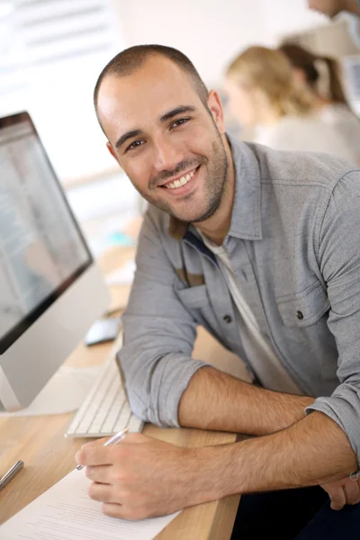 Smiling guy in front of computer — Stock Photo, Image