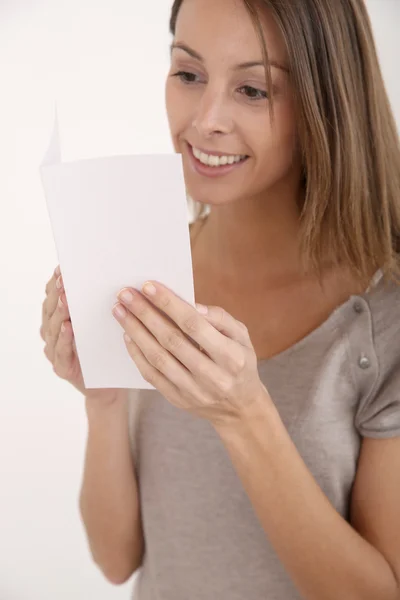 Mujer sonriente sosteniendo folleto para el mensaje — Foto de Stock