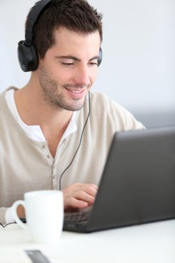 adamın önündeki dizüstü bilgisayar